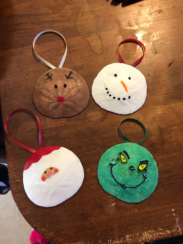 four handmade christmas ornaments sitting on top of a wooden table