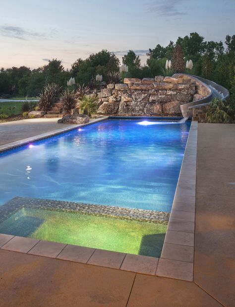 an empty swimming pool in the middle of a backyard with stone steps leading up to it