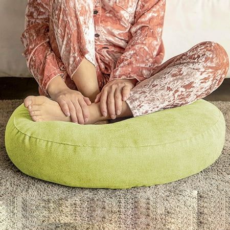 a woman sitting on top of a green bean bag chair