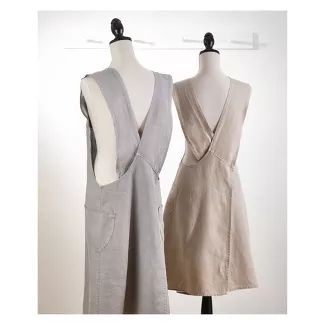 two women's dresses on mannequins in front of white wall