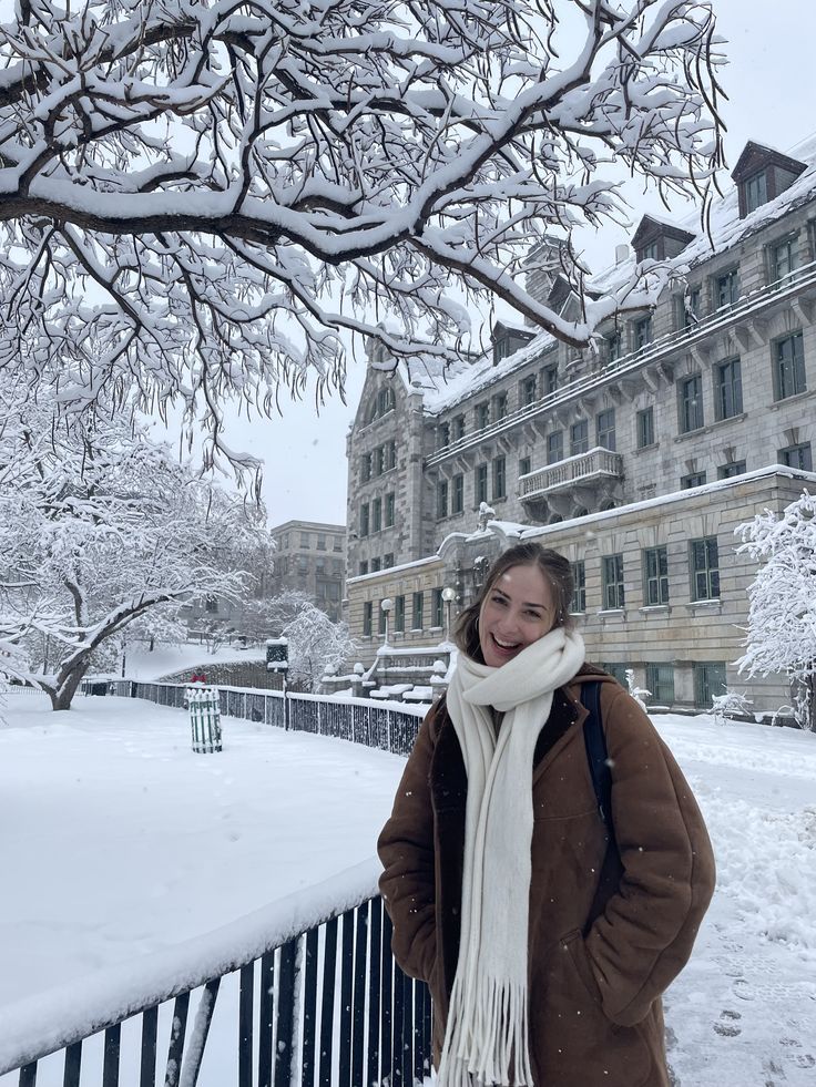 a woman standing in front of a building on a snowy day