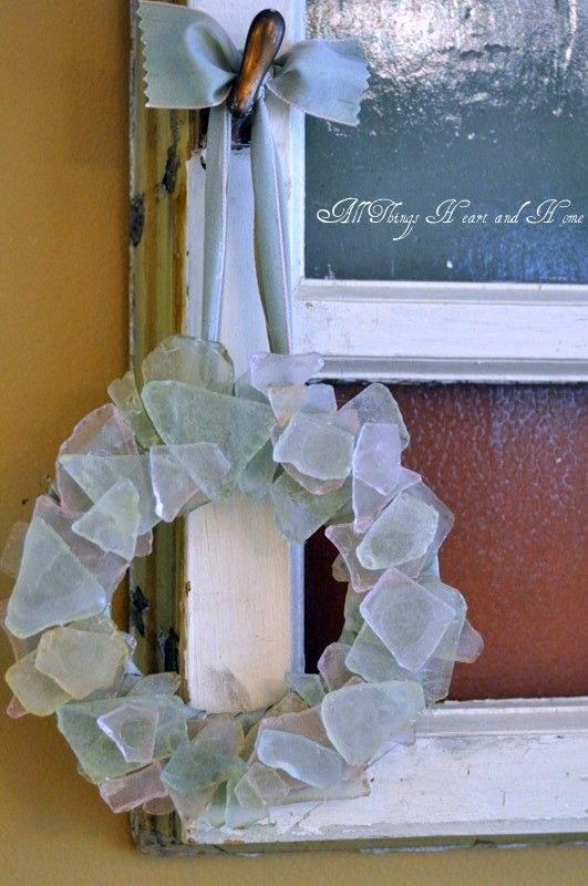 a wreath is hanging on the wall next to an old frame with a chalkboard