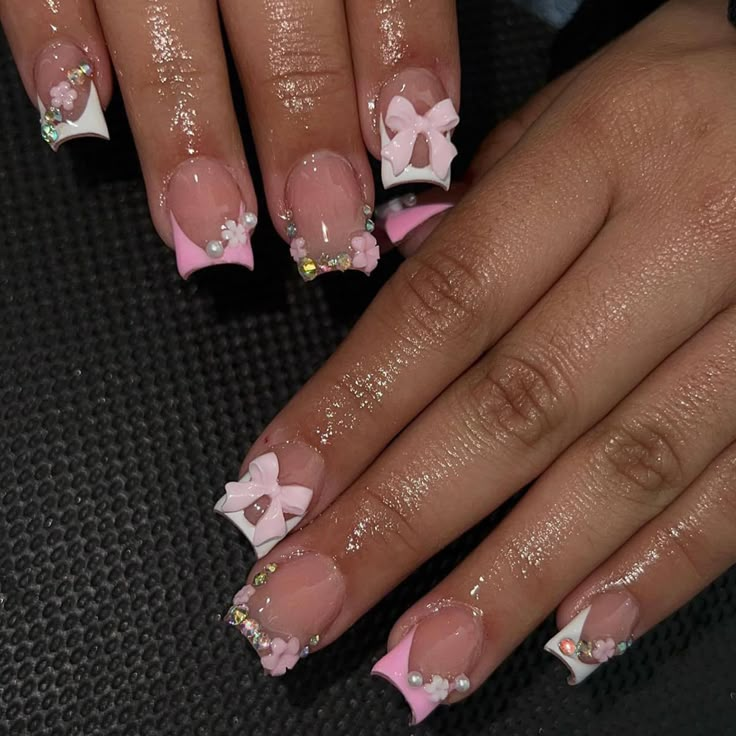 a woman's hands with pink and white french manies decorated with bows on them