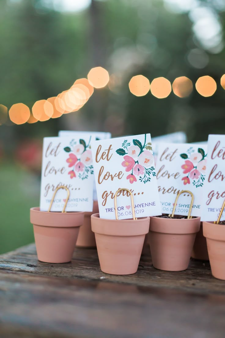 small flower pots with place cards on them