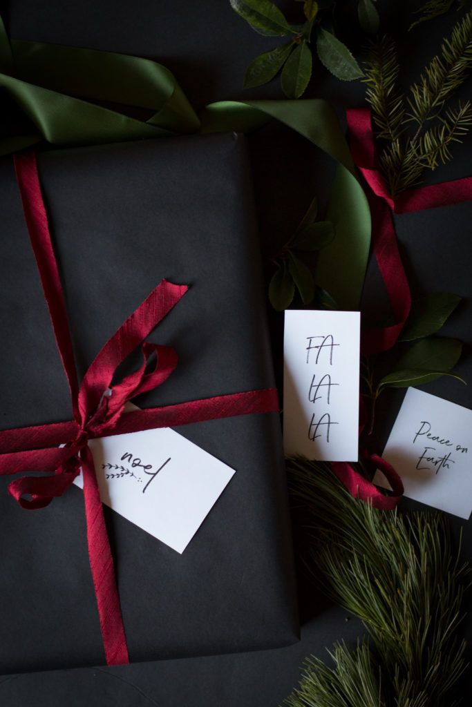 two presents wrapped in black paper and tied with red ribbon