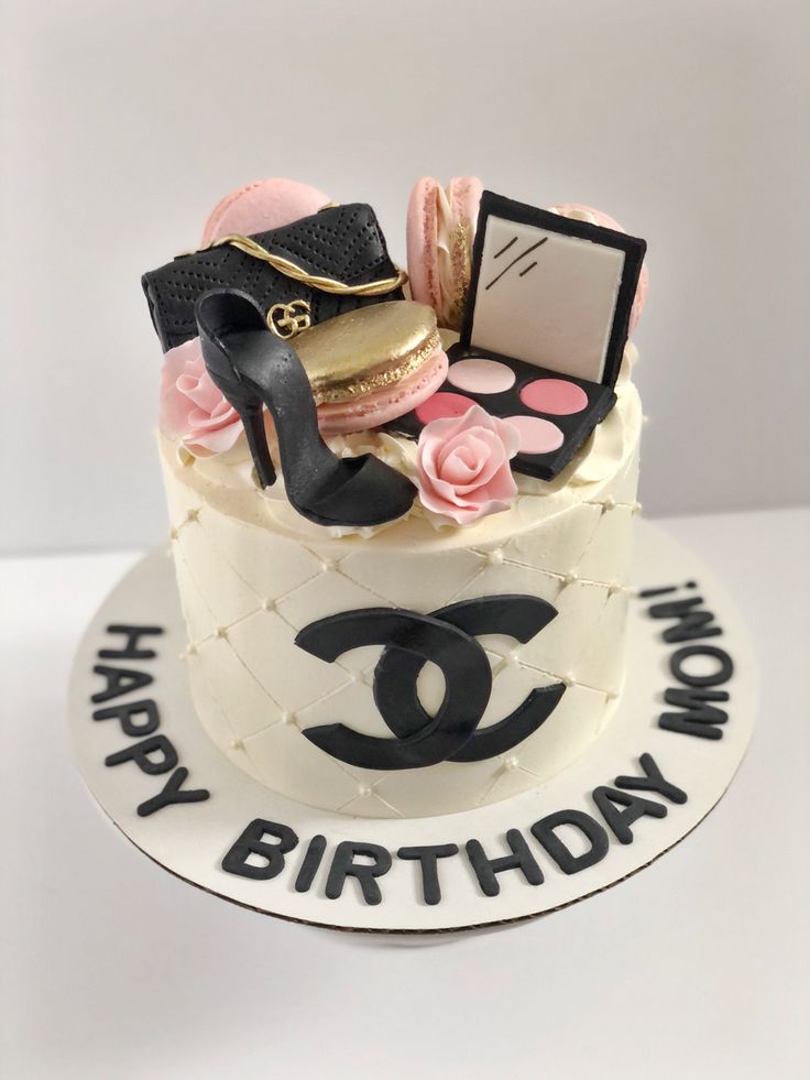 a birthday cake decorated with chanel shoes, lipstick, and purses on top