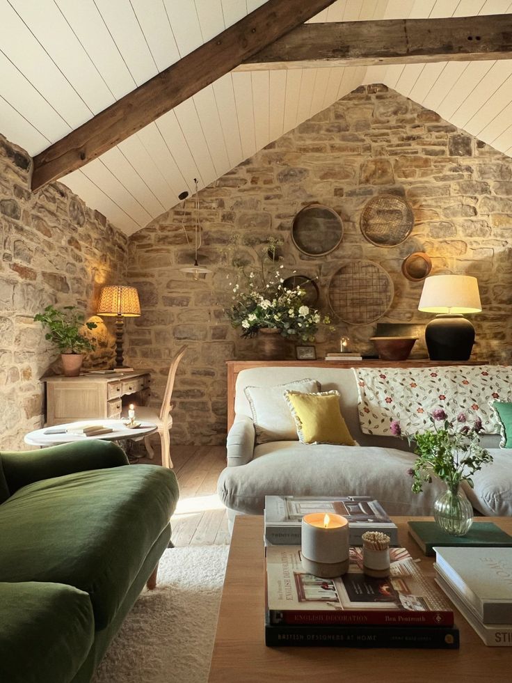 a living room filled with furniture and a stone wall covered in exposed beams is shown