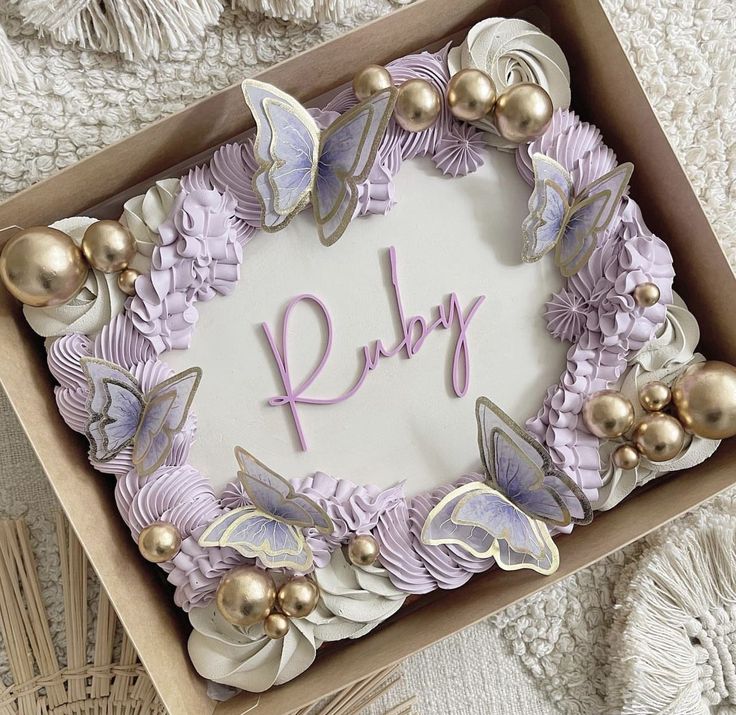 a cake in a box with the word ruby written on it and some decorations around it