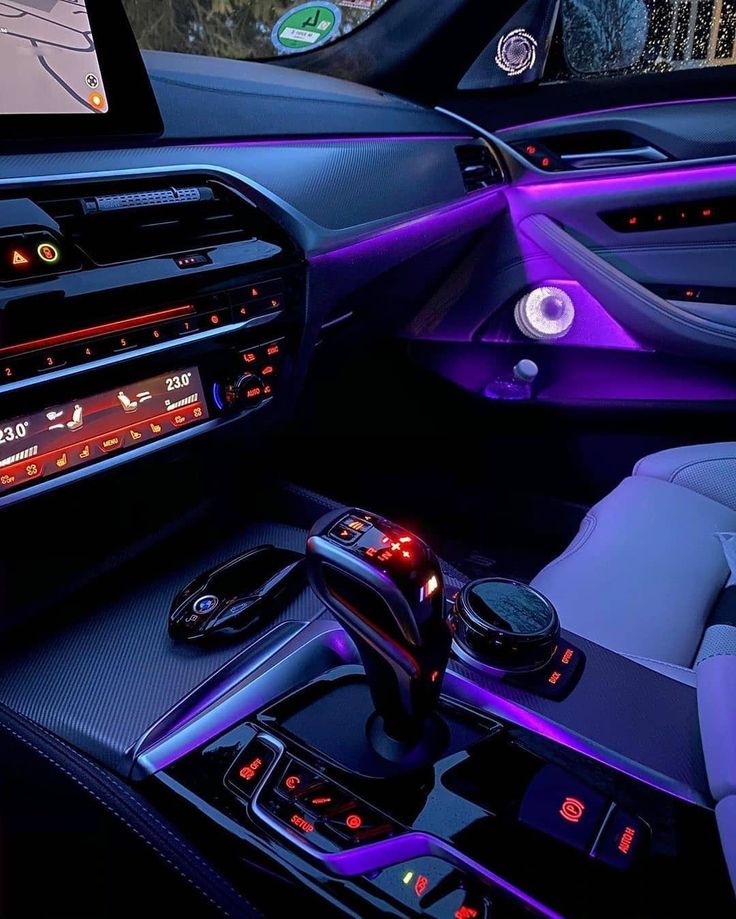 the interior of a modern car with purple lighting