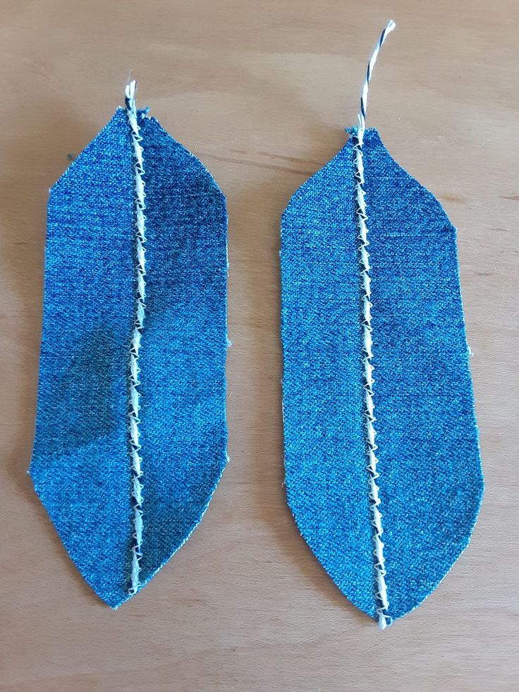 two pieces of blue fabric hanging from strings