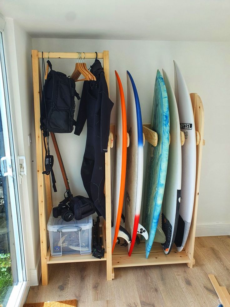 several surfboards are lined up against a wall in a room with wood flooring