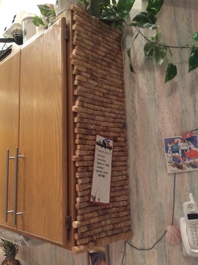 a wooden cabinet sitting on top of a wall next to a phone and planter