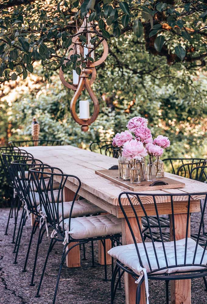 an outdoor table with chairs and flowers on it