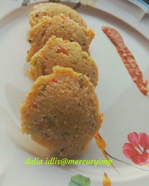 two pieces of food sitting on top of a white plate next to a flowered table cloth