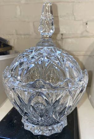 a clear glass bowl sitting on top of a black table next to a white brick wall