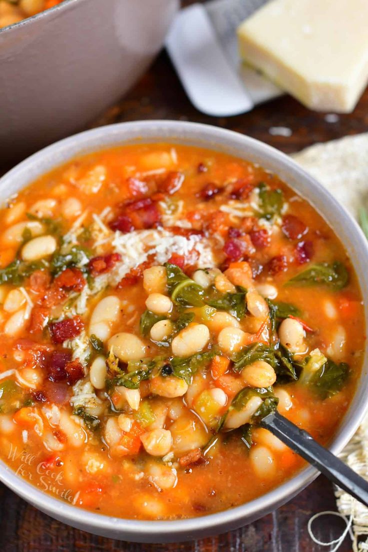 a white bowl filled with beans, spinach and cheese