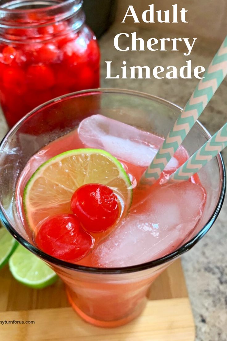 a close up of a drink in a glass with ice and cherries on the rim