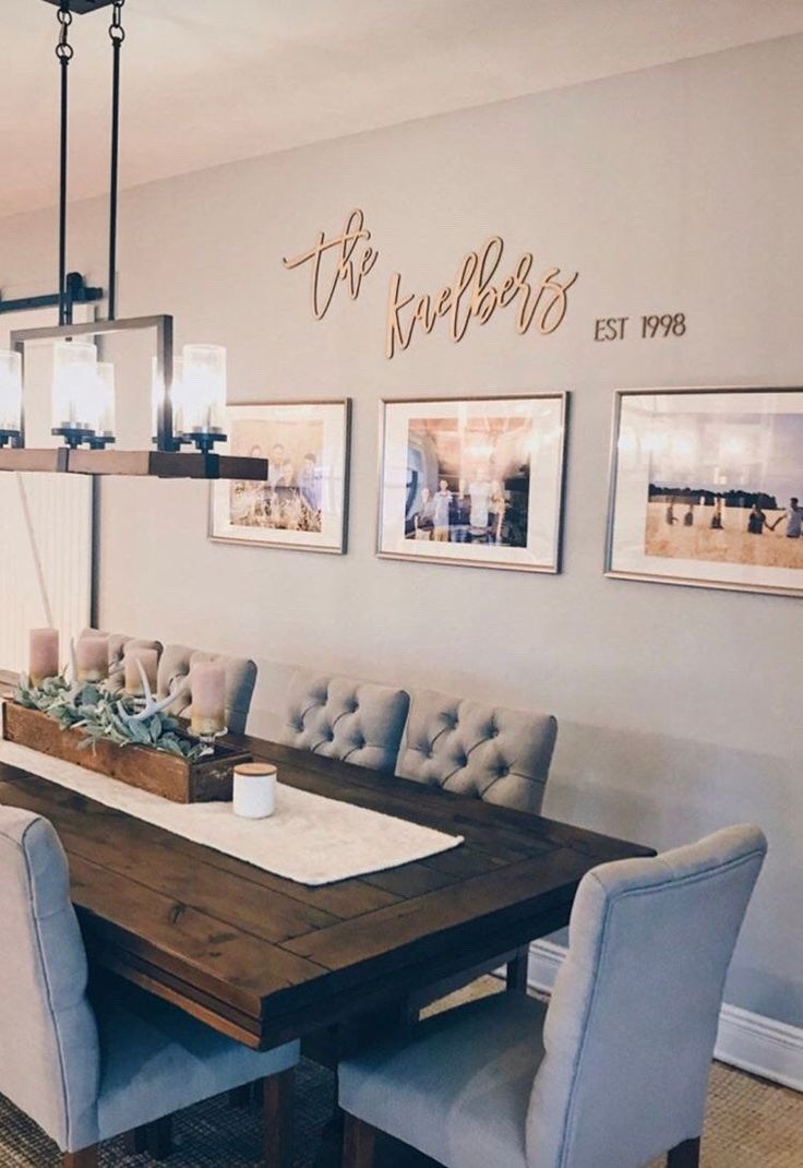 a dining room table with chairs and pictures on the wall above it, along with other furniture