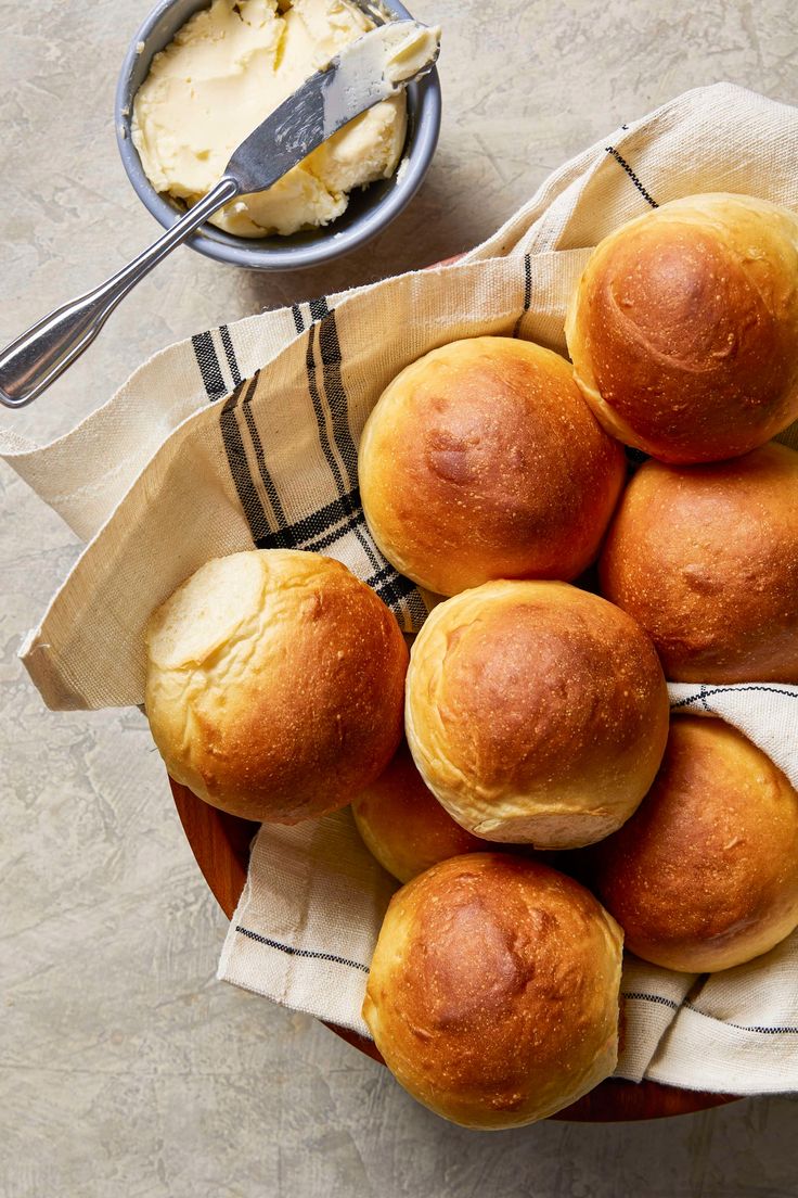 a bowl filled with rolls and butter on top of a table