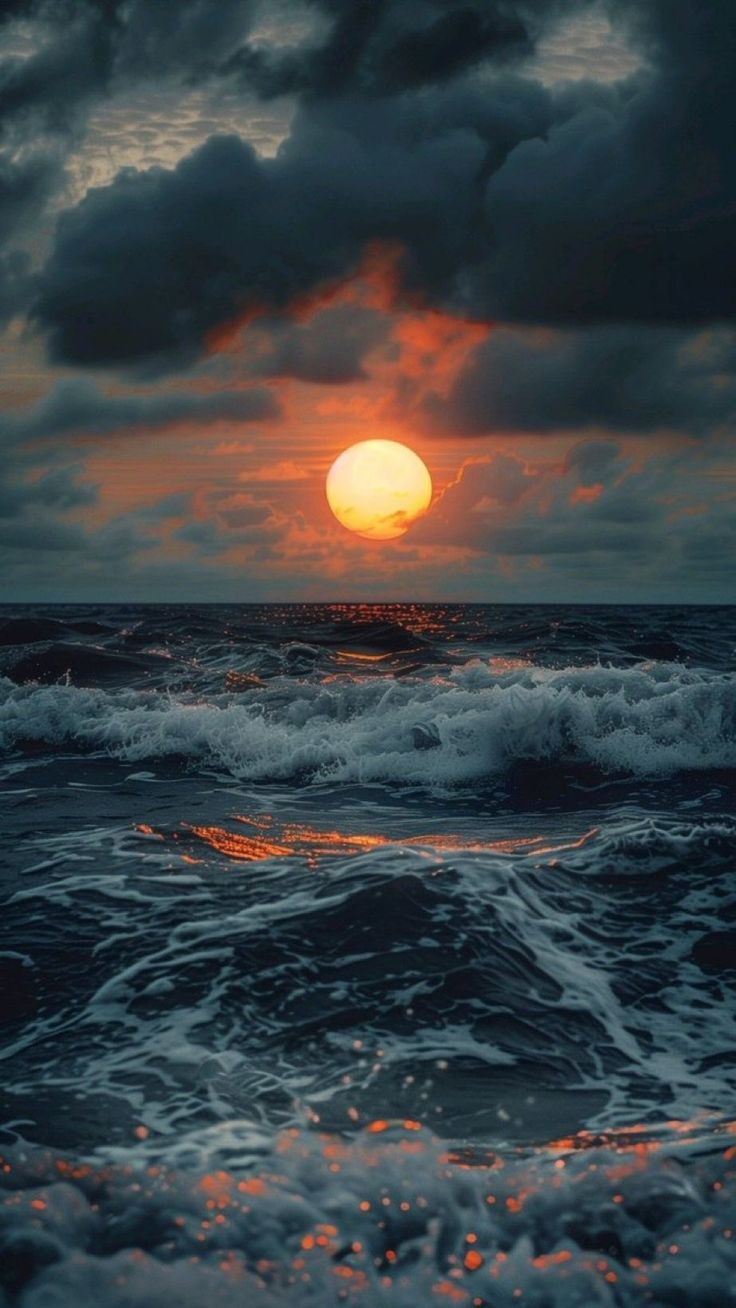 the sun is setting over the ocean with waves crashing in front of it and dark clouds