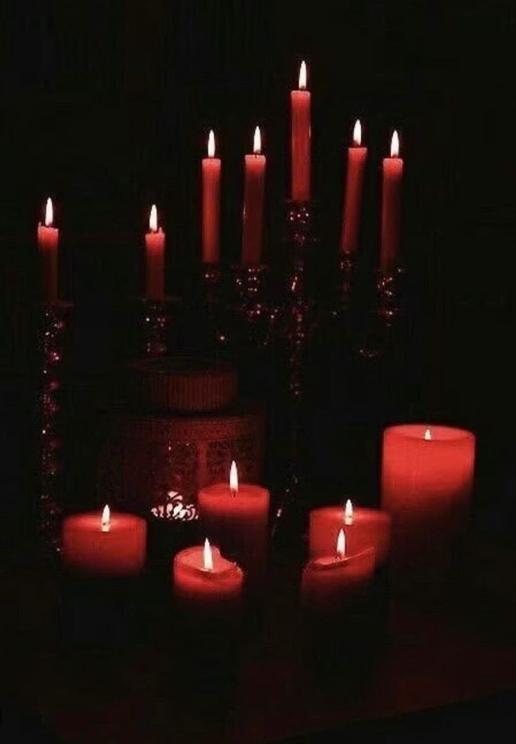 many lit candles are arranged in the dark