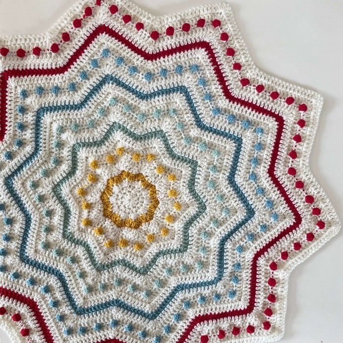 a crocheted doily is shown in red, white, and blue colors