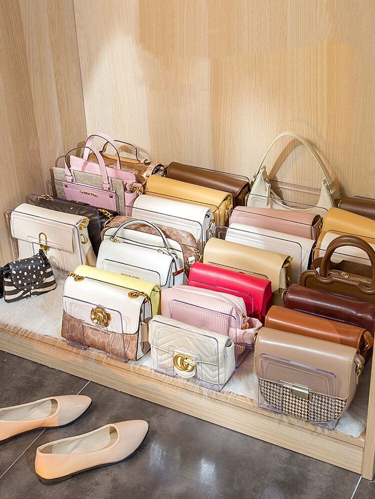 many different colored purses are on display in a case next to shoes and handbags