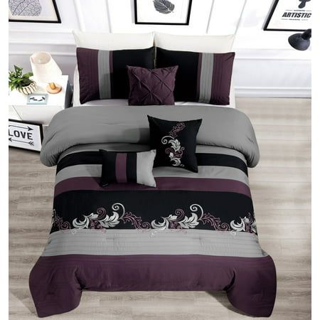 a bed with purple and grey comforters in a room next to pictures on the wall