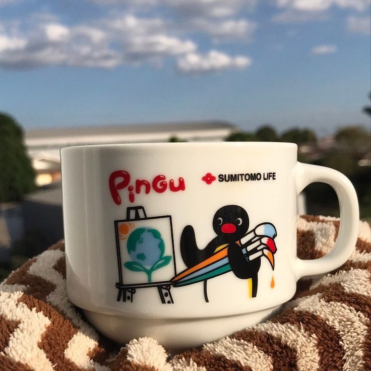 a coffee cup sitting on top of a blanket