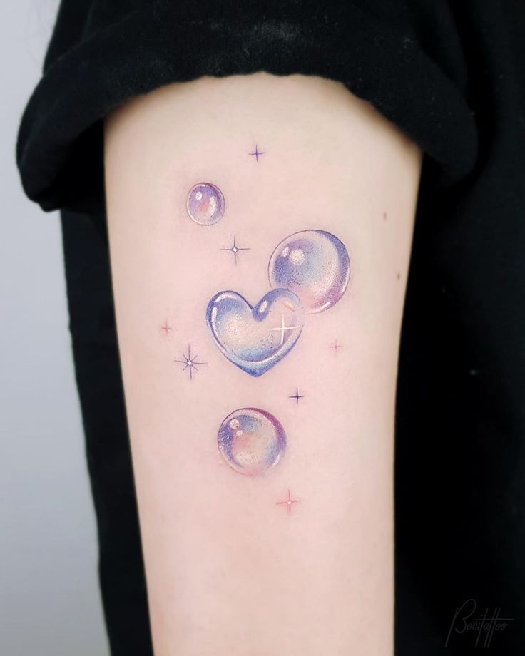 a woman with a tattoo on her arm that has two hearts and stars in it