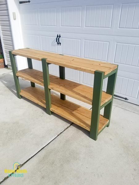 a large wooden shelf sitting on top of a cement floor next to a garage door