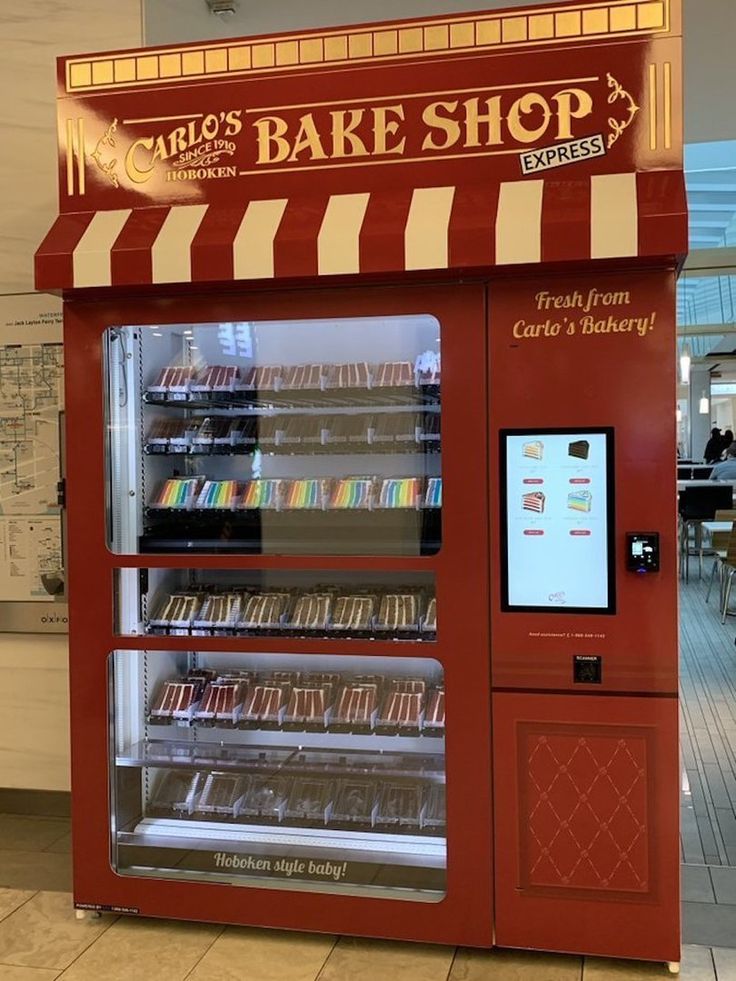 a red and white striped store front with an ice cream machine in the foreground