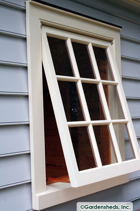 an open window on the side of a house with blue siding and wood shingles