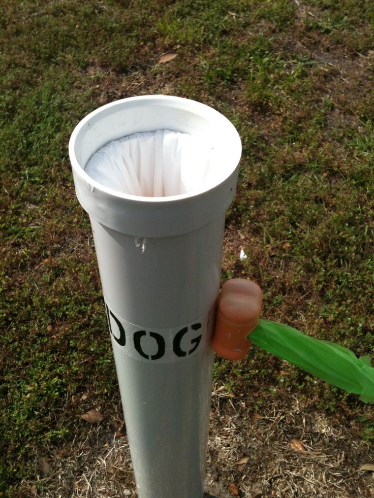 a person holding a plastic cup in their hand and throwing it into the trash can