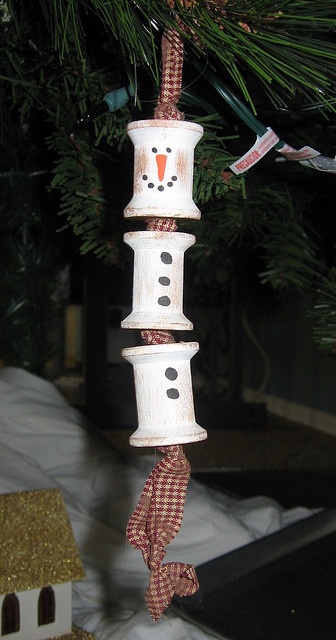 a snowman ornament hanging from a christmas tree