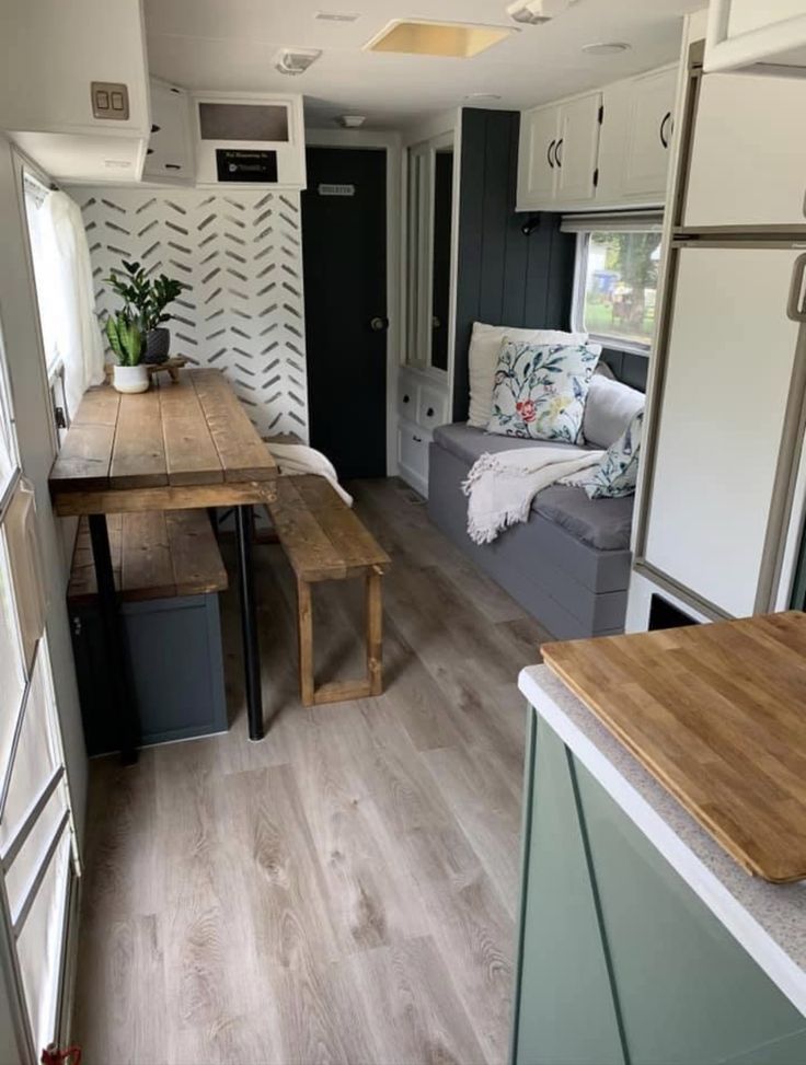 a kitchen and living room in an rv with wood flooring on the inside walls