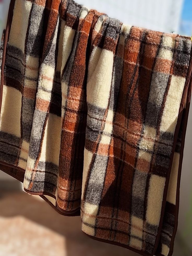 a brown and white checkered blanket hanging from a clothes line