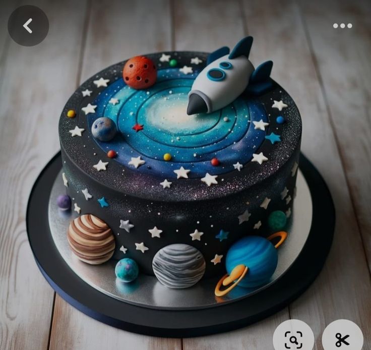 a space themed cake with planets, stars and a rocket ship on it's side