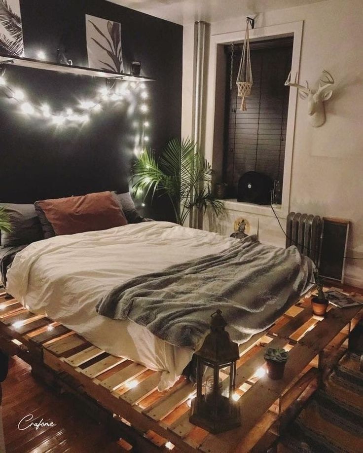 a bed made out of pallets with lights on the headboard and foot board