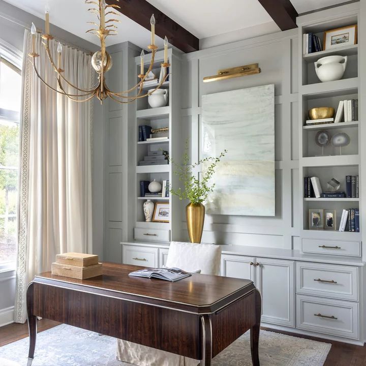 an elegant office with built in bookcases and desk