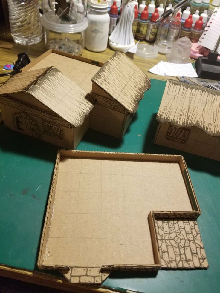 three cardboard houses sitting on top of a table