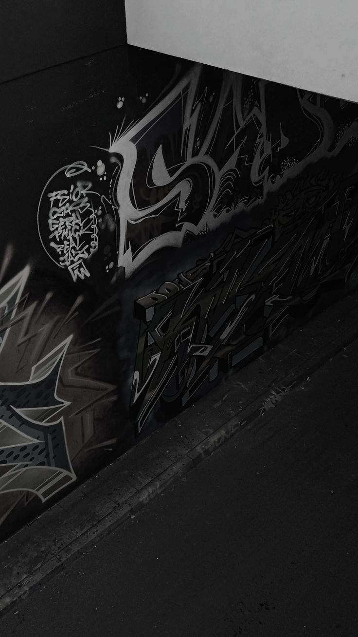 a man riding a skateboard down the side of a wall covered in grafitti