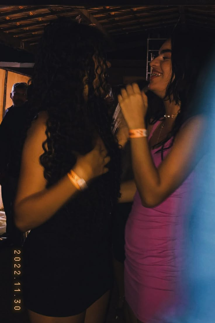 two women standing next to each other at a party