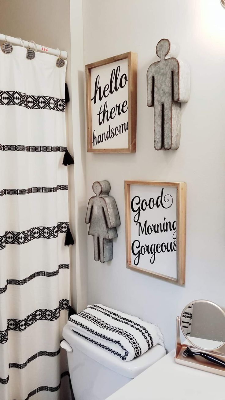 a bathroom decorated in black and white with pictures on the wall above the toilet seat