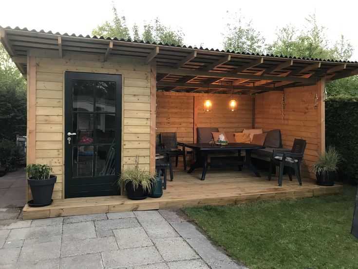 a small wooden house with patio and dining area