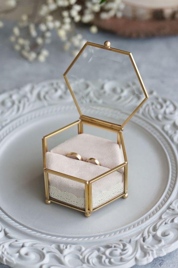 two wedding rings in a ring box on a plate