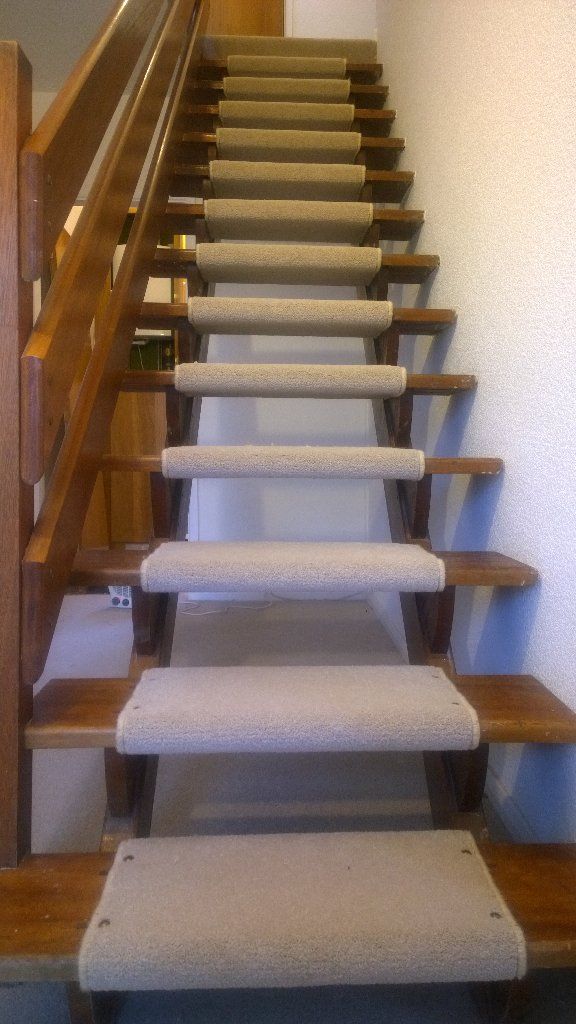 a set of stairs with carpeted treads and wooden handrails