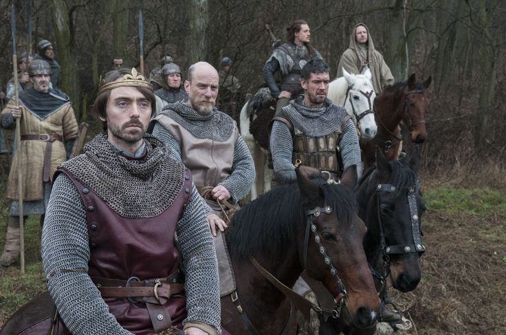 a group of men riding on the backs of horses in front of people wearing armor