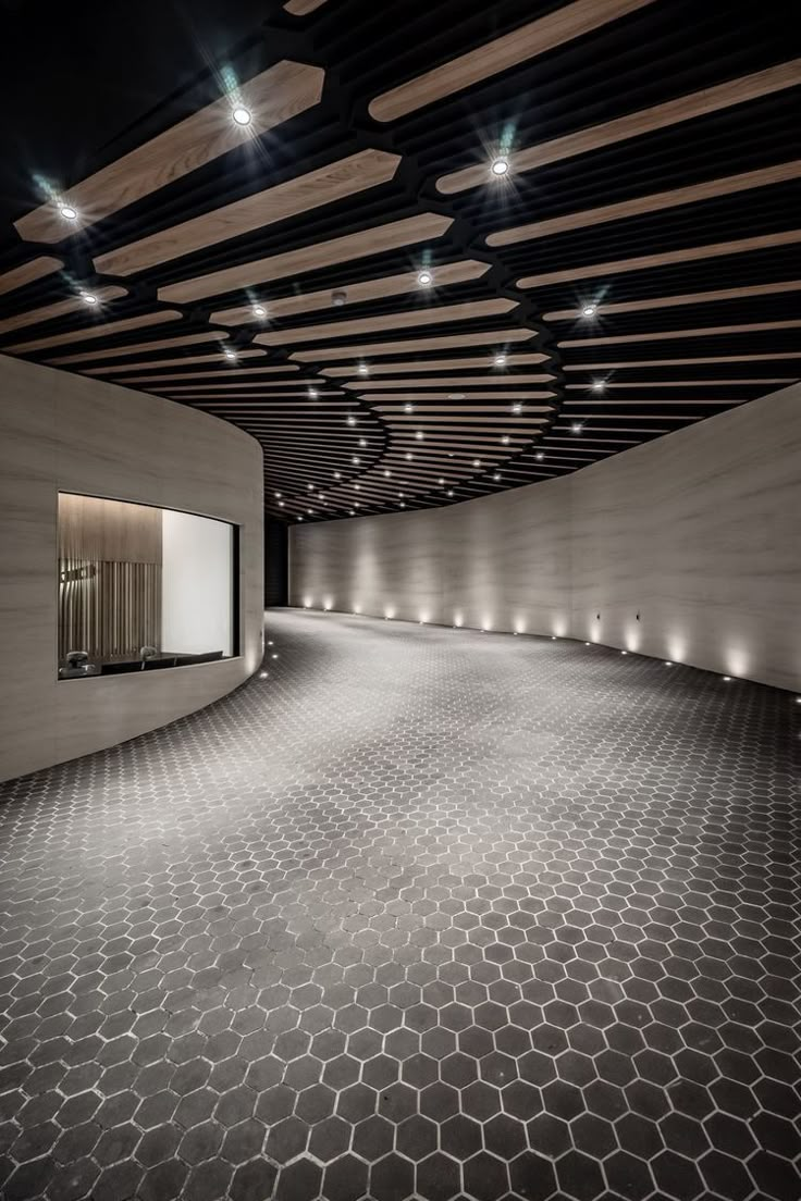 an empty room with lights on the ceiling and hexagonal tile flooring that looks like honeycombs