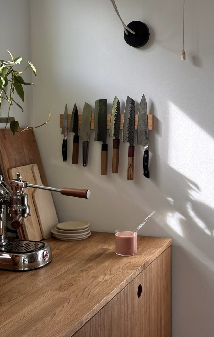 a kitchen counter with knives hanging on the wall